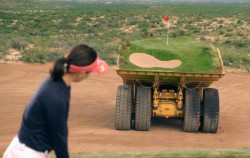 Caterpillar machines playing golf in the desert